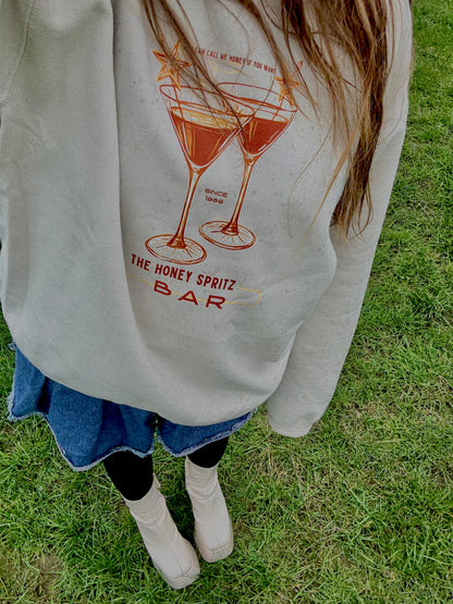 Person wearing a sweatshirt with a graphic design on grass

